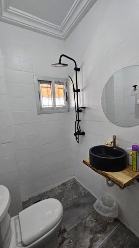 a bathroom with a black sink and a toilet at Résidences C-Irène Angré in Abidjan