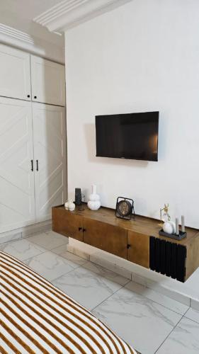 a living room with a television on a white wall at Résidences C-Irène Angré in Abidjan