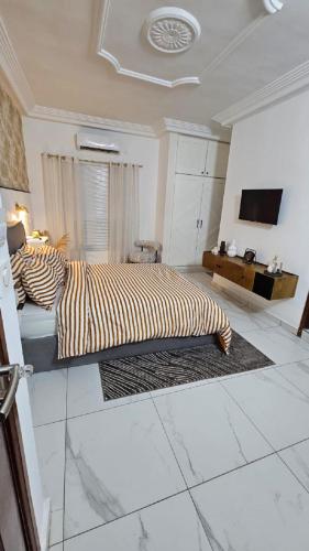a bedroom with a bed and a tv on a wall at Résidences C-Irène Angré in Abidjan
