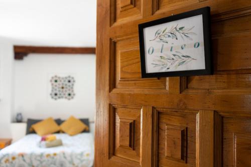a wooden door with a picture of a bed in a room at Oripando Private Rooms in Granada