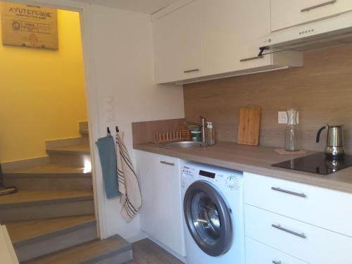 une cuisine avec une machine à laver et un évier dans l'établissement Chez Mo T1 indépendant avec son jardin privatif, à Sète