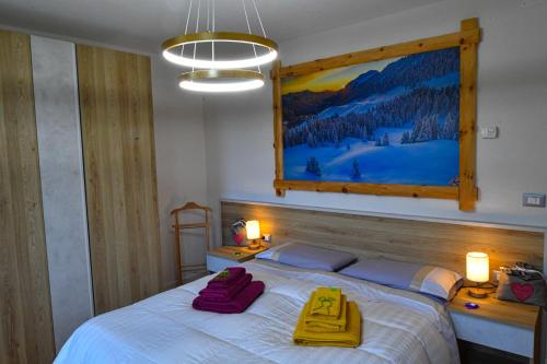 1 dormitorio con 1 cama con 2 toallas amarillas en Appartamento Bucaneve, en Pieve Tesino