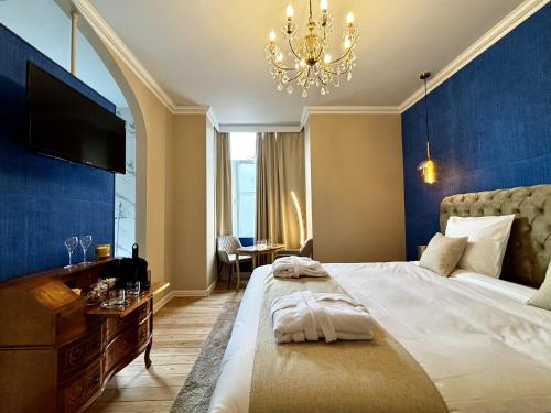 a bedroom with a large bed and a chandelier at Maison du Roi in Liège