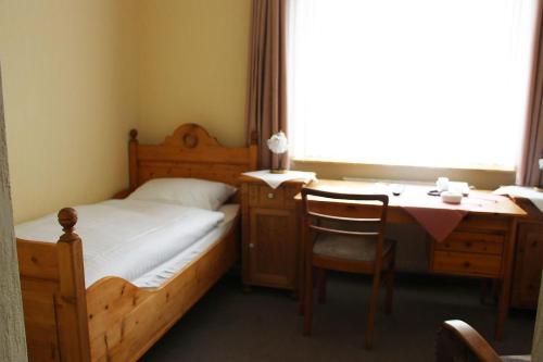 sypialnia z łóżkiem, biurkiem i stołem w obiekcie Döhling's Gasthaus w mieście Morsum