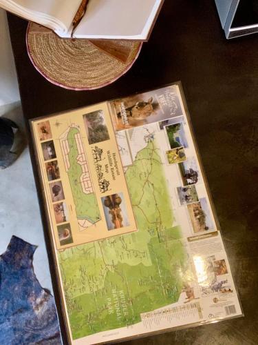 a map on a table next to a book at Rooibos Luxury Bush Cottage in Hoedspruit