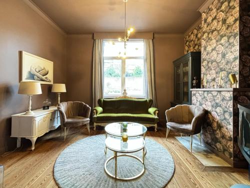a living room with a green couch and chairs at Maison du Roi in Liège