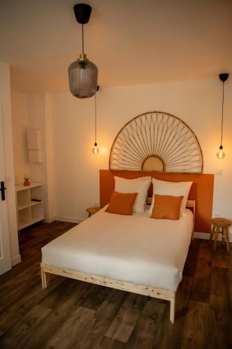 - une chambre avec un grand lit blanc et une tête de lit en bois dans l'établissement La halte ducale #1, à Charleville-Mézières