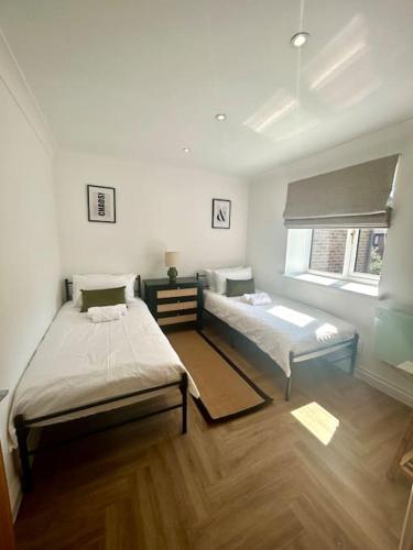 a bedroom with two beds and a window at Brand new City centre apartment with parking in Cardiff