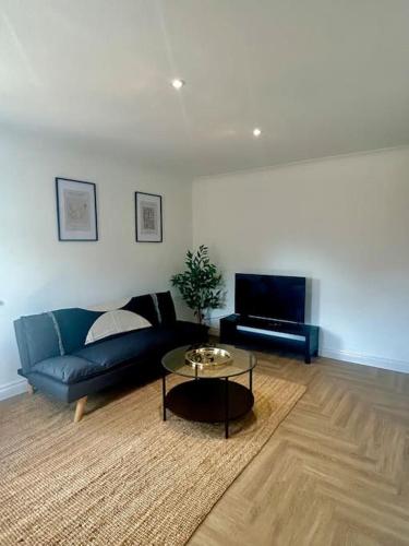 a living room with a couch and a table at Brand new City centre apartment with parking in Cardiff