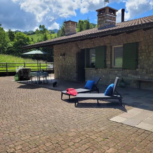 a patio with two chairs and a table and a building at La Casa di Angi in Onore