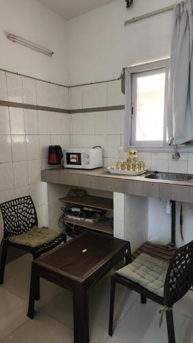 a kitchen with a table and two chairs and a sink at Diadia Apartment 2 in Dakar