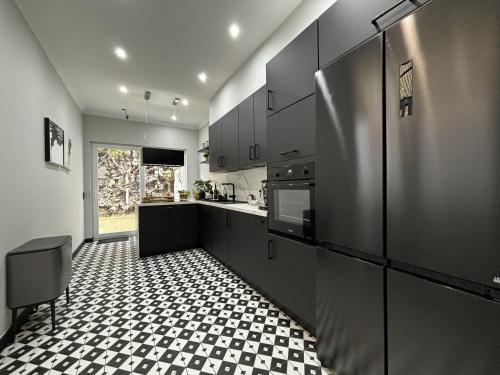 a kitchen with black cabinets and a checkered floor at Maison du Roi in Liège