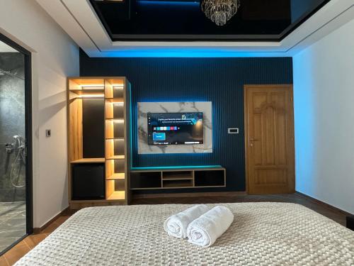 a bedroom with a bed with a tv on the wall at Blue Star Apartments in Ulcinj