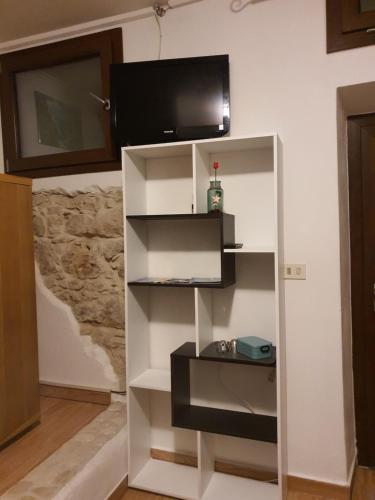 a white book shelf with a tv on a wall at Montecool in Baunei