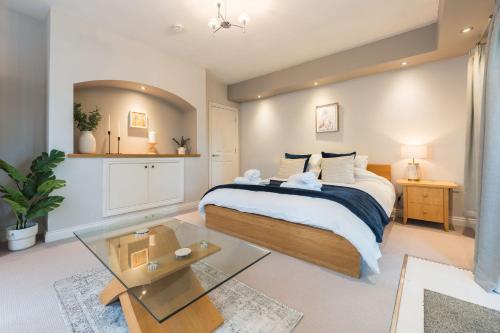 a bedroom with a bed and a glass table at The Failand Retreat Luxury Stay in Flax Bourton