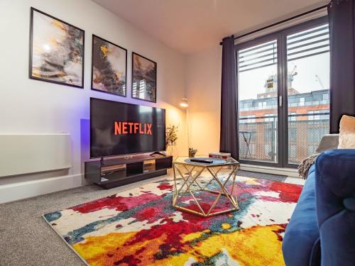 a living room with a tv and a large window at Central Birmingham Apartment with Balcony & Netflix in Birmingham