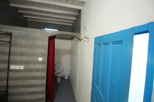 uma casa de banho com portas azuis e vermelhas e um WC em ASARAG em Mirleft