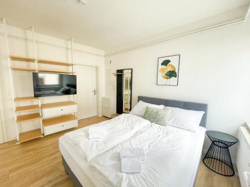 1 dormitorio con 1 cama blanca y TV en StayHere Central City Studio 4 - contactless Self-Check-IN, en Graz