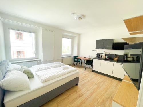 Habitación blanca con cama y cocina en StayHere Central City Studio 4 - contactless Self-Check-IN, en Graz