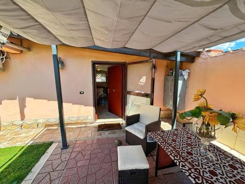 a patio with an umbrella and a chair and a table at La casetta holiday in Fiumicino