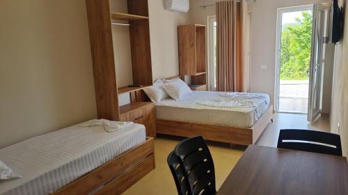 a bedroom with two beds and a table and chairs at Sol Apartments Gjiri Lalzit in Durrës