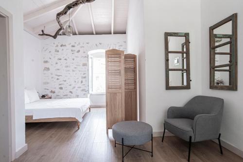 a bedroom with a bed and a chair and a mirror at Militiko in Himare