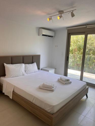 a bedroom with a large bed with two towels on it at Front Sea Villa Polichrono in Kriopigi