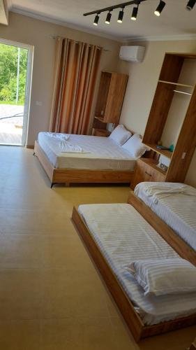 a bedroom with two beds and a window at Sol Apartments Gjiri Lalzit in Durrës