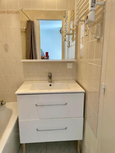 a bathroom with a white sink and a mirror at L'ALOUETTE maison 4/5pers PISCINE/MER Cabourg à pied in Dives-sur-Mer