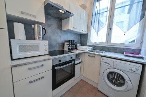 une cuisine avec un lave-linge et un micro-ondes dans l'établissement Grande Eugénie proche Opéra, Kiosque, Casino, Cure, à Vichy
