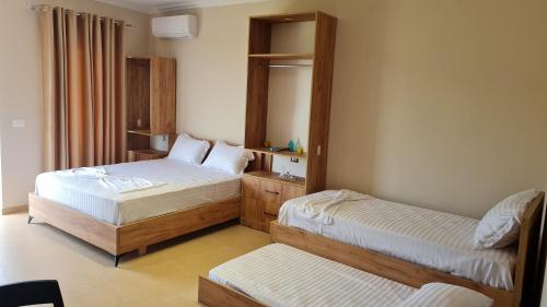 a bedroom with two beds and a mirror at Sol Apartments Gjiri Lalzit in Durrës