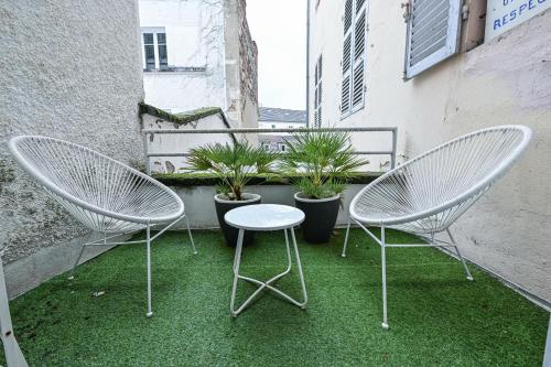 2 chaises et une table sur un balcon avec des plantes dans l'établissement Grande Eugénie proche Opéra, Kiosque, Casino, Cure, à Vichy
