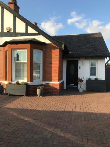 a house with a brick driveway in front of it at Caerlaverock Cottage in Prestwick