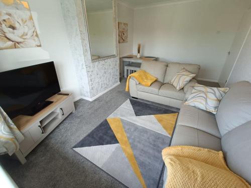 a living room with a couch and a flat screen tv at Alton Towers/Foxfield & Oak Barns/Peak District in Wetleyrocks