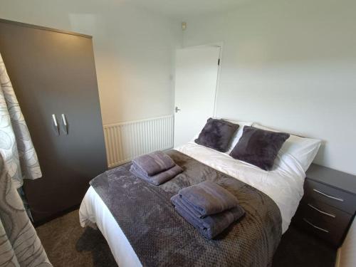 a bedroom with a bed with two pillows on it at Alton Towers/Foxfield & Oak Barns/Peak District in Wetleyrocks
