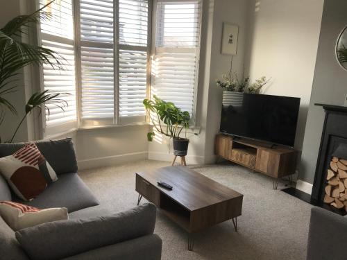 a living room with a couch and a tv at Caerlaverock Cottage in Prestwick