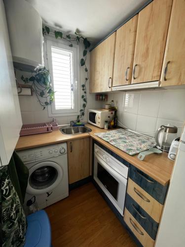 a small kitchen with a sink and a microwave at Coqueto ático con vistas al mar y a la montaña Auto Check-in in Miami Platja