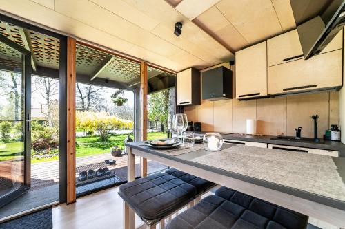 uma cozinha em plano aberto com uma grande bancada e cadeiras em A tiny house with a garden and a hot tube em Pringi