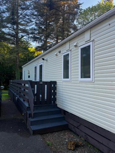 a mobile home with stairs leading up to it at The Forest Cabin Holiday Home 15 in Ballantrae