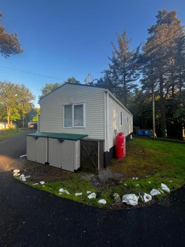 a house with a ping pong table in front of it at The Forest Cabin Holiday Home 15 in Ballantrae