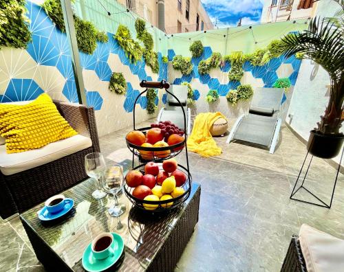 un cesto di frutta su un tavolo sul patio di Elegante Apartamento TRES COLORES ad Alicante