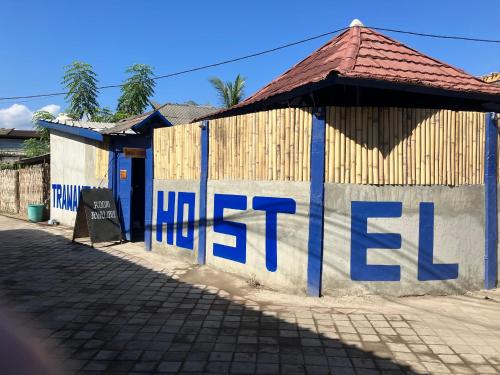 a building with blue writing on the side of it at Hostel Gili Trawangan in Gili Trawangan
