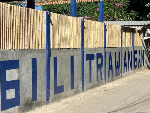 een hek met blauwe letters erop bij Hostel Gili Trawangan in Gili Trawangan