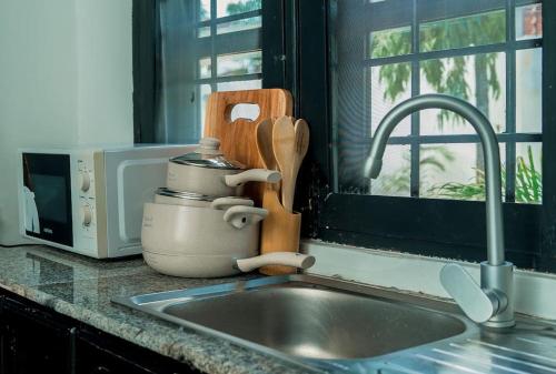 - un évier de cuisine avec un mixeur à côté d'une fenêtre dans l'établissement GE-Homes, à Dar es Salaam