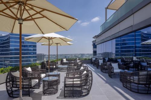 a patio with tables and chairs and umbrellas on a building at Marriott Marquis Dubai Creek in Dubai