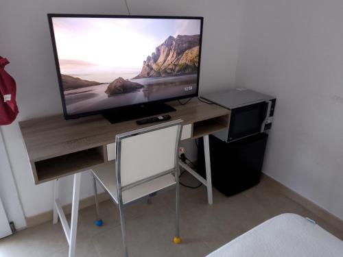 菲烏米奇諾的住宿－Vinci Residence，木制书桌上配有平面电视
