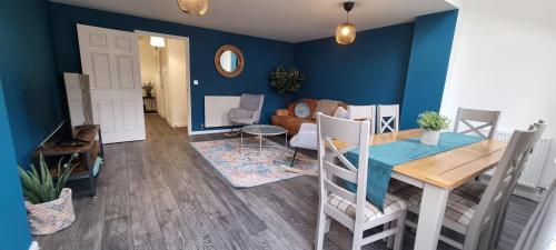 a living room with a table and a blue wall at Guildhall - Beauluxe Properties large property - 3 bedroom - 4 beds - sleeps upto 6 people in Church Gresley