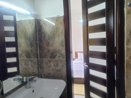 a bathroom with a sink and a shower at Oasis in the City. Victoria Island serviced apt. in Lagos