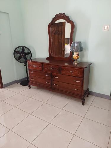 a dresser with a mirror and a lamp on it at Embassy deluxe 2 in Kingston