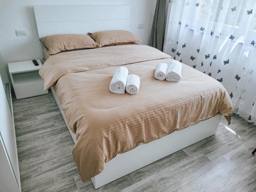 a bedroom with a bed with two towels on it at Cosy apartment Fagaras in Făgăraş